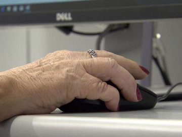 Idosa utilizando computador como ferramenta para exercitar a mente