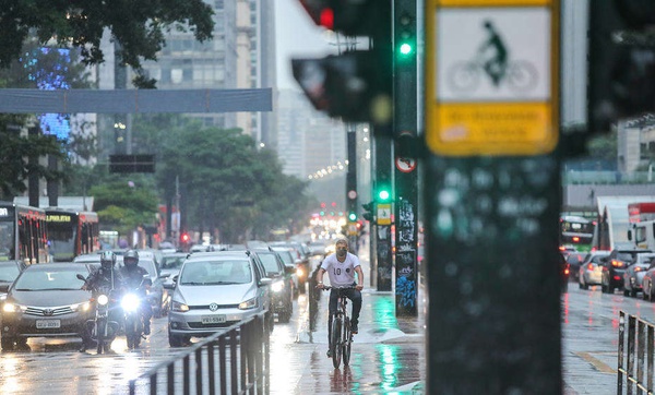 Ciclista pedala na Avenida Paulista em momento de trânsito de carros