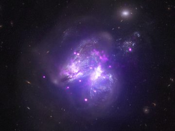 Galáxia Arp 299: sistema em que duas galáxias estão se fundindo, com estrelas de cada galáxia se misturando entre si.