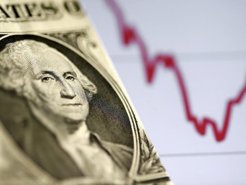 Nota de dólar em frente a um gráfico de ações