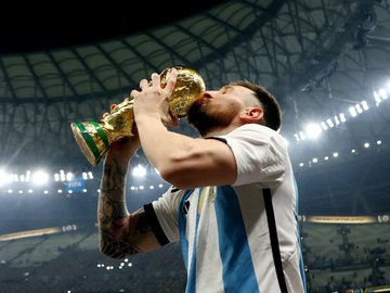 Lionel Messi beija a taça da Copa do Mundo após a conquista do tri da Argentina