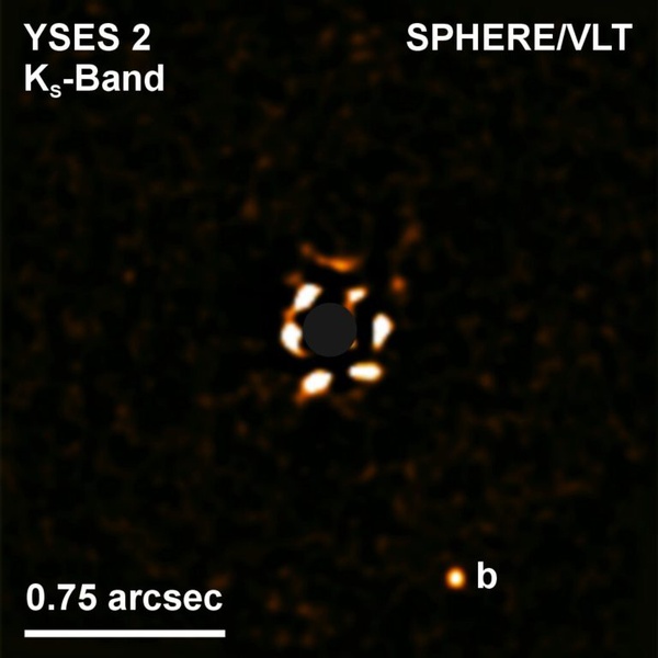 Imagem direta do exoplaneta YSES 2b (canto inferior direito) e sua estrela (centro). A luminosidade da estrela é bloqueada a fim de que o planeta possa ser visto.