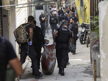 Policiais carregam corpo durante operação na favela do Jacarezinho