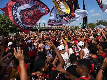 Torcedores do Flamengo fazem festa no Galeão enquanto aguardam chegada de ônibus do Flamengo.