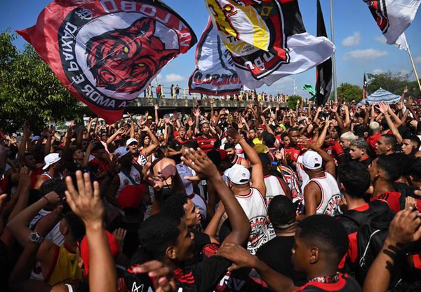 Torcedores do Flamengo fazem festa no Galeão enquanto aguardam chegada de ônibus do Flamengo.