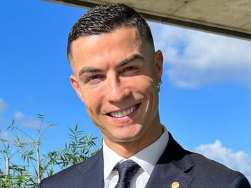 Cristiano Ronaldo sorridente, de terno