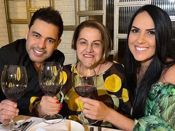 Zezé Di Camargo posa sorridente ao lado da esposa e da sogra